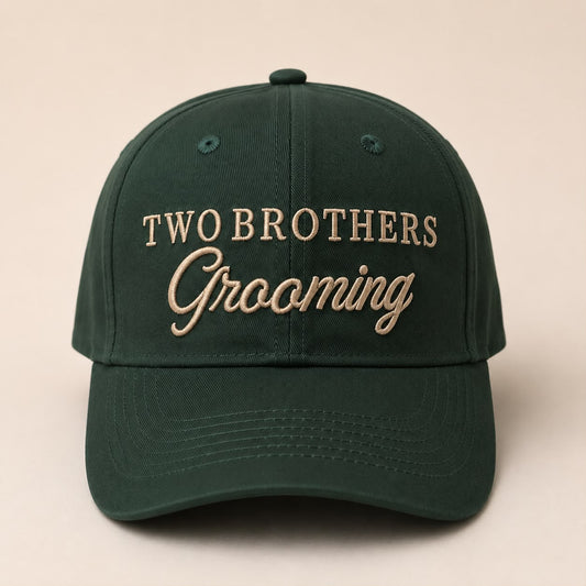 Green cap with 'Two Brothers Grooming' text on a beige background