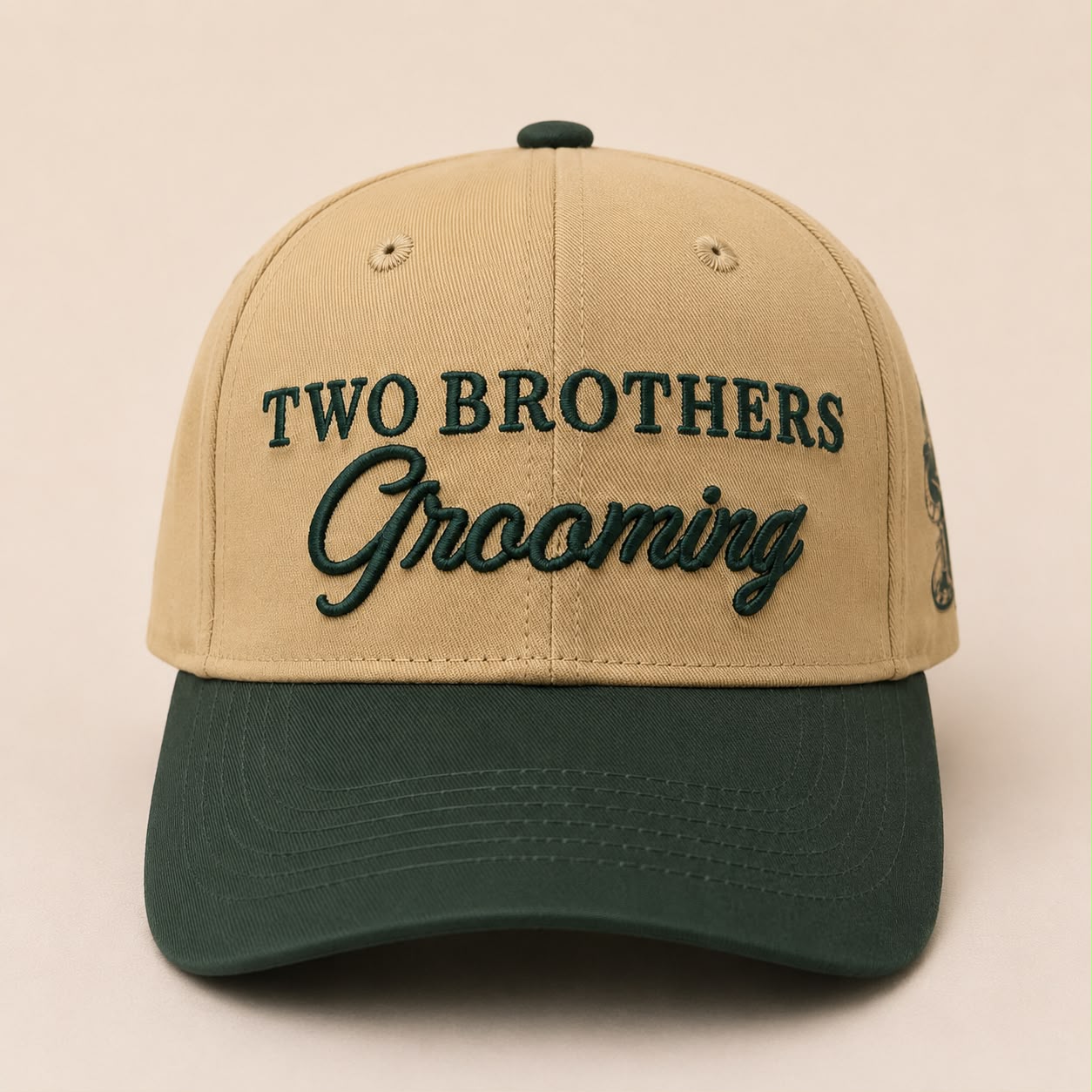 Beige and green cap with 'Two Brothers Grooming' text on a beige background
