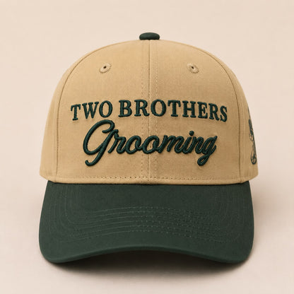 Beige and green cap with 'Two Brothers Grooming' text on a beige background
